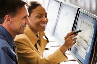 Two business people working together looking at a computer screen